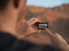 Person taking a photo of a desert landscape with a smartphone