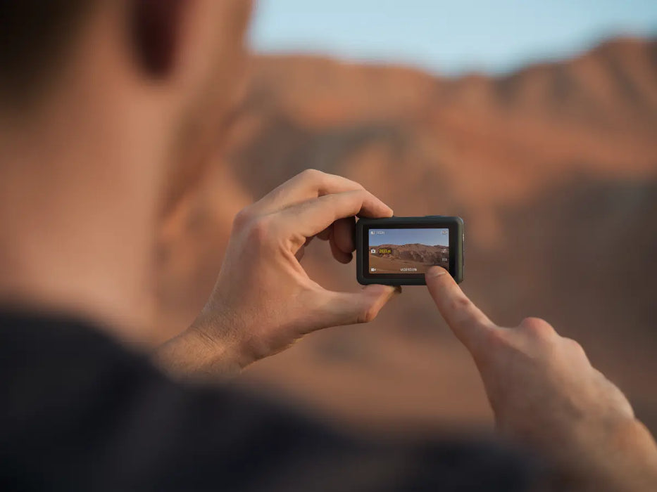 Person taking a photo of a desert landscape with a Osmo Action