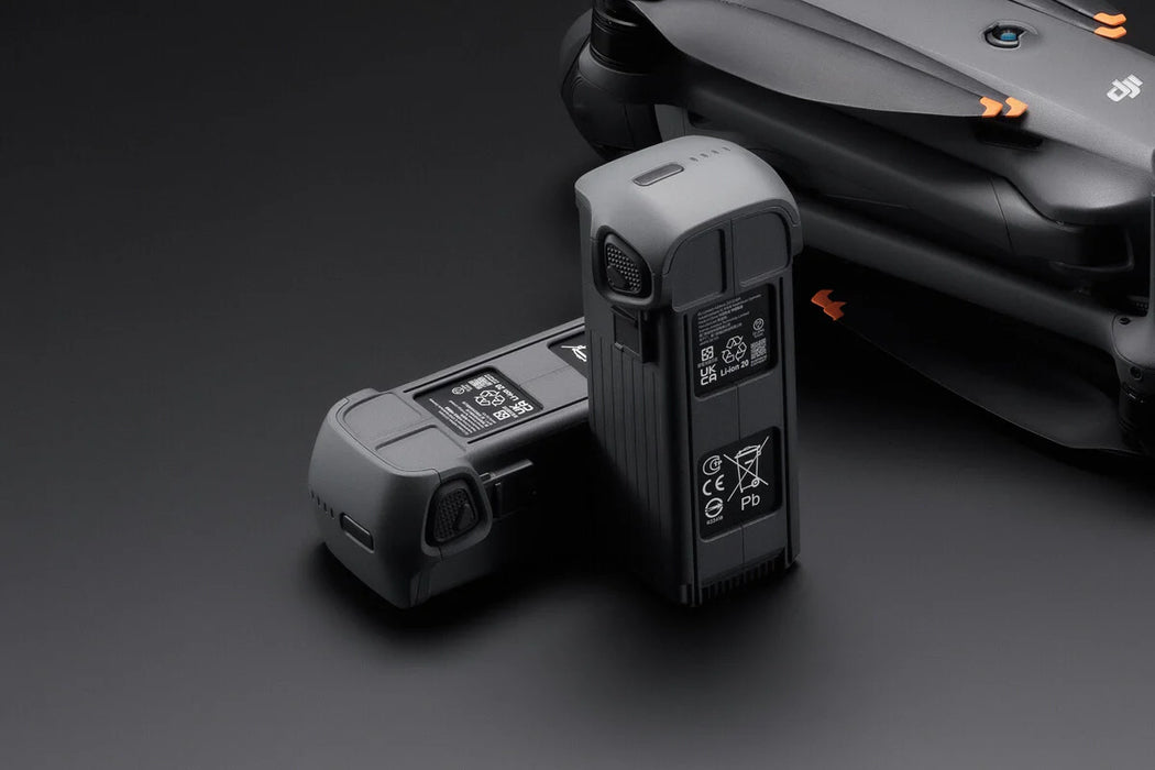 Two drone batteries on a dark background